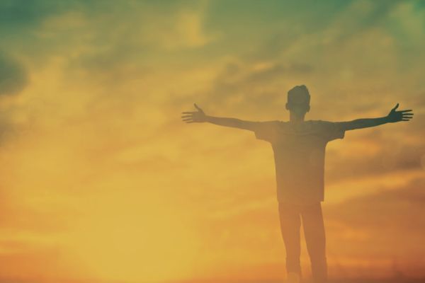 man with arms open towards the sun